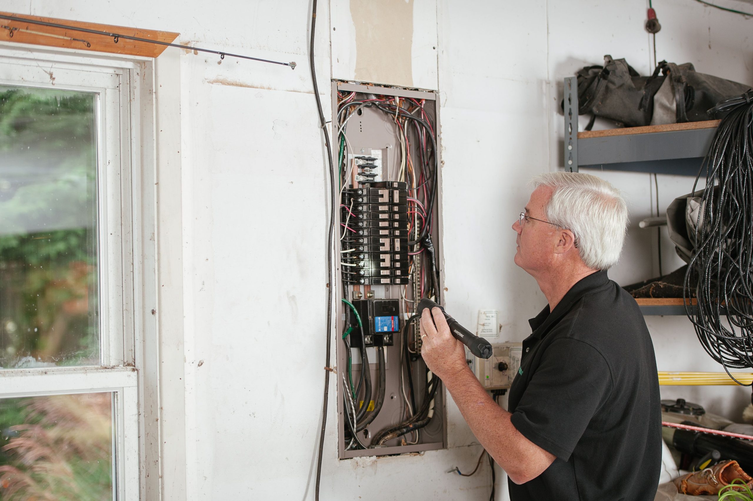 Electricien examine tableau électrique résidentiel