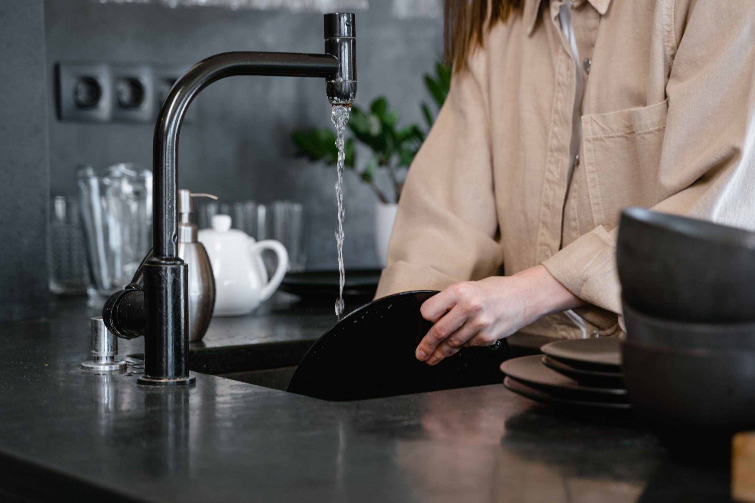 Personne lavant la vaisselle en cuisine moderne