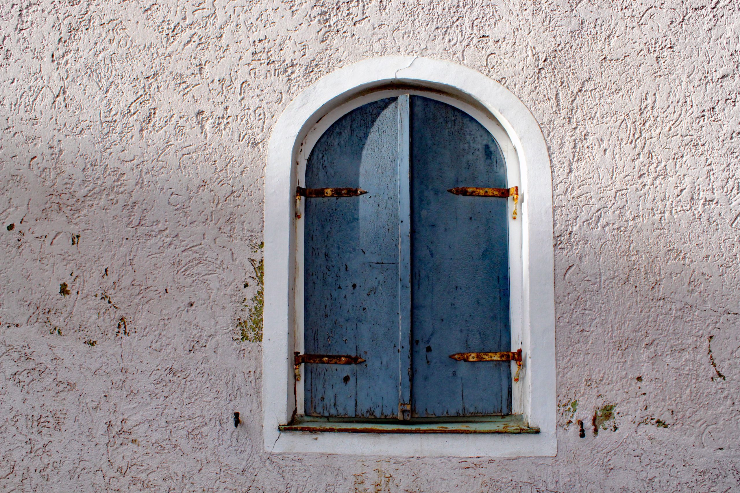 Vieux volet bleu sur un mur en pierre ancien