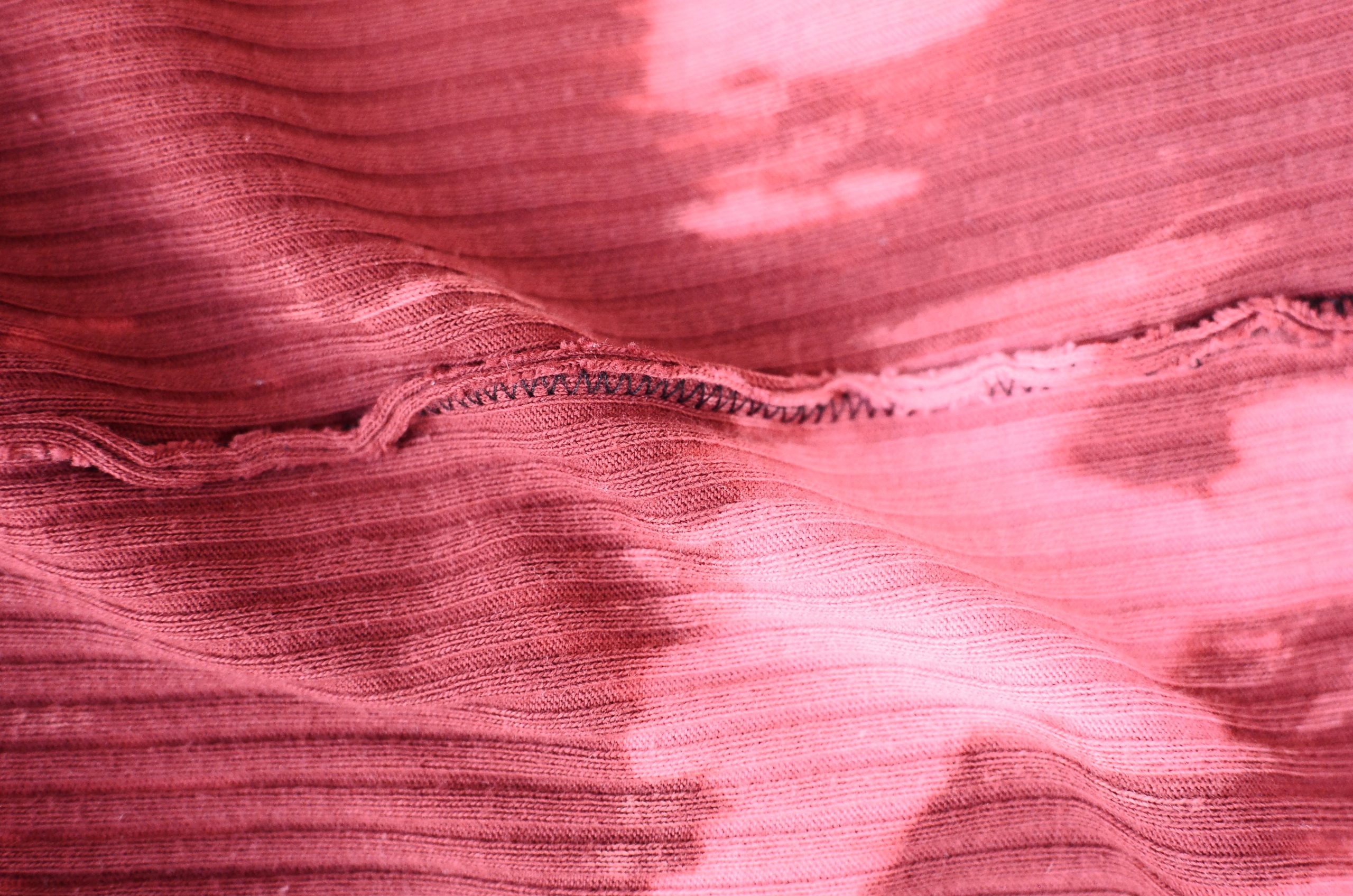 Tissu rose tricoté avec taches posé sur table